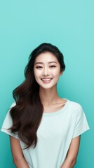 Teal background Happy Asian Woman Portrait of young beautiful Smiling Woman good mood Isolated on Background Skin Care Face Beauty Product Banner with copyspace