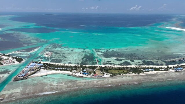 Aerial view of luxury resort on tropical island with turquoise waters and reef, Addu Atoll, Maldives.