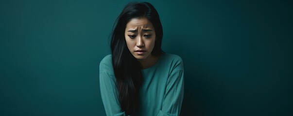 Teal background sad Asian Woman Portrait of young beautiful bad mood expression Woman Isolated on Background depression anxiety fear burn out health issue problem mental 