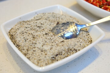 salt and pepper Different types of salt in glass bowls on a dark gray table. Background for advertising salt. Table salty. Salted food.