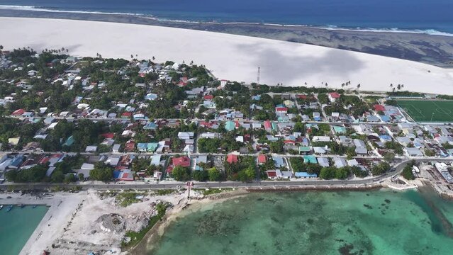 Aerial view of harbor, boats, houses, and reclamation in Addu City Development Project, Maradhoo, Addu Atoll, Maldives.