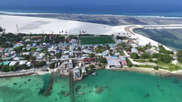 Aerial view of turquoise shore with boats and houses in Maradhoo, Addu Atoll, Maldives.