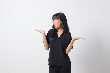 Portrait of excited Asian woman in casual shirt spreading hands making choice, choosing between two...