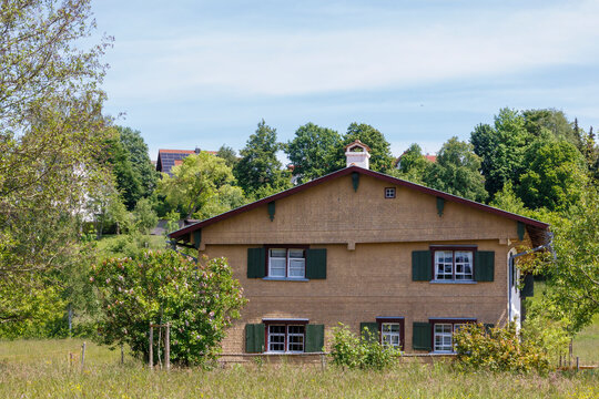 A historic flat-roofed farmhouse from 1740 with a wooden shingle fa&ccedil;ade