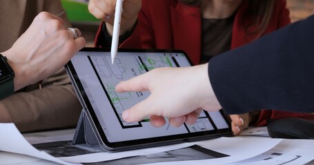 Interior designers using tablet for design, focusing on floor plan details Integrating traditional...