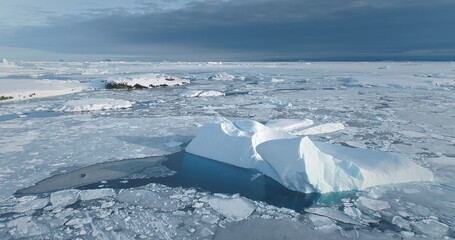 Snow covered iceberg in frozen icy polar ocean. A massive iceberg floating Antarctica coast. Arctic...