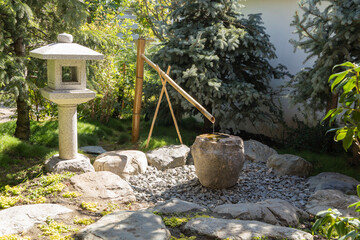 Japanese garden in Galitsky Park in Krasnodar. Cho-zu bamboo fountain and traditional Japanese lantern. Lantern Yukimi Toro. Cho-zu is name of a bamboo stream in Japan.