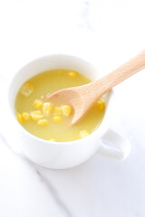 熱々のコーンクリームスープをスプーンでかきまぜる
