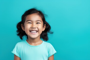Aqua background Happy Asian child Portrait of young beautiful Smiling child good mood Isolated on backdrop ethnic diversity equality acceptance concept with copyspace 