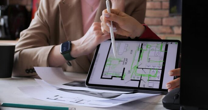 Designers offer apartment layout to client before renovation. Architects guide customer through rooms plan on tablet highlighting key features and design elements, innovative ideas, environment