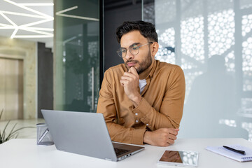 Young professional working on a laptop in a modern office