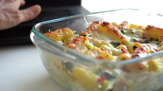 Woman eating lunch in Tupperware in the office while working on a laptop
