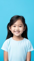 Blue background Happy Asian child Portrait of young beautiful Smiling child good mood Isolated on backdrop ethnic diversity equality acceptance concept with copyspace 