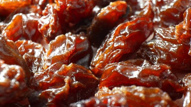 The black raisins, with their intricate creases and rich tones of dark brown, seem to dance in the light, radiating an aura of succulence and freshness.
