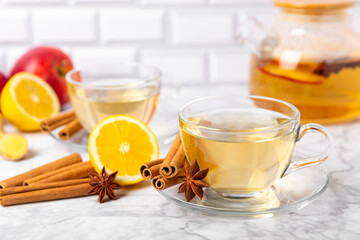 Fragrant hot tea with cinnamon stick and anise on a textured wooden background. A cup of hot tea...