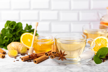 Fragrant hot tea with cinnamon stick and anise on a textured wooden background. A cup of hot tea...