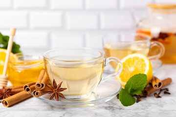 Fragrant hot tea with cinnamon stick and anise on a textured wooden background. A cup of hot tea...