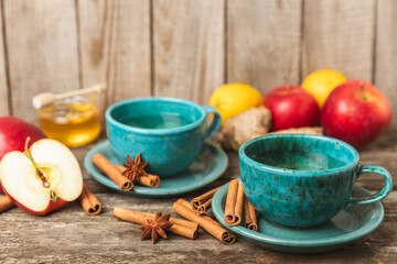 Fragrant hot tea with cinnamon stick and anise on a textured wooden background. A cup of hot tea...