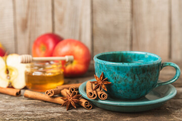 Fragrant hot tea with cinnamon stick and anise on a textured wooden background. A cup of hot tea...