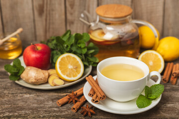 Fragrant hot tea with cinnamon stick and anise on a textured wooden background. A cup of hot tea...