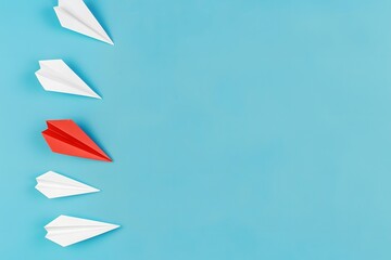 Top view of paper planes with one red and three white on blue background