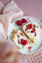 Berry pavlova rolle with raspberries and almond and whipped cream, pink background