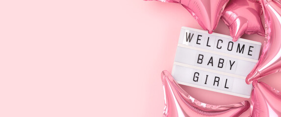 Welcome baby girl. Banner with lightbox and foil balloons in a pink color.