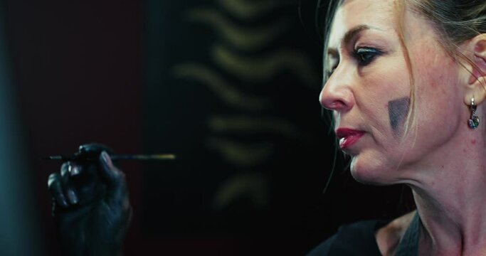 Woman Painting With Paintbrush in Dark Room