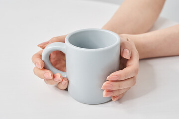  	マグカップを持つ女性の手元