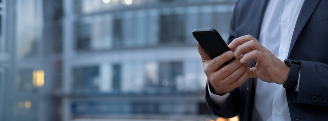 Closeup banner shot of business man hands using app holding smartphone cellphone at office...