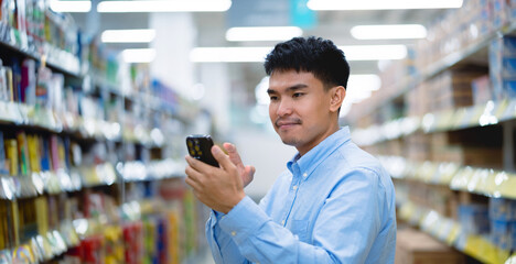 Asian young man choosing in supermarket Male customers standing in the grocery store. Salesperson...