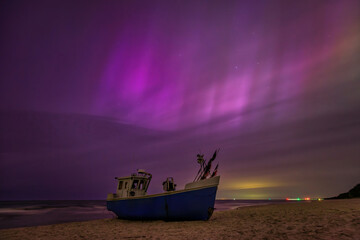 Aurora over the Baltic Sea on the beach in Katy Rybackie with fishing boat in Poland.