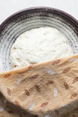 Overhead view of bread dough rising in banneton basket , top view of proofing dough in a wood proofing basket, process of making bread