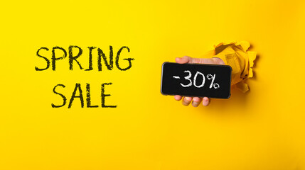 A person holding a cell phone with the words Spring Sale written on it