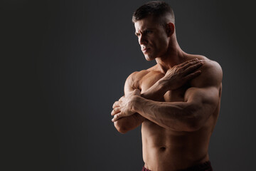 Muscular model sports young man on dark background. Fashion portrait of strong brutal guy. Male...