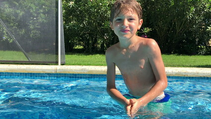 Child swimming towards camera. Young boy at pool
