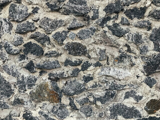 A wall made of stone with a lot of black and white stones