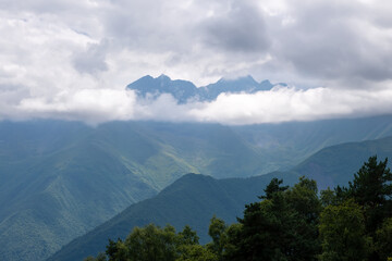Clouds cover the peaks of the mountains. View of the Caucasus Mountains in Ingushetia, Russia