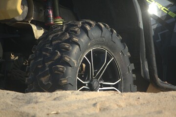Rear wheel of a Can-Am ATV on the sandy beach