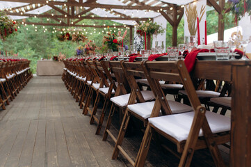 wedding holiday banquet in the open air. covered, served tables in the yard, garden in nature. wooden tent covered with fabric, wedding banquet