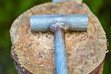 old hammer made of metal, tool lying on a tree trunk at the Viking festival, or medieval market, Schonungen, Schweinfurt, Germany