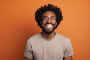 Fototapeta premium Portrait of a joyful afro-american man in his 40s smiling at the camera isolated on blank studio backdrop