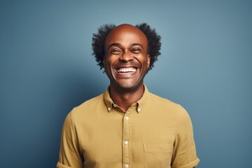 Obraz premium Portrait of a joyful afro-american man in his 40s smiling at the camera on blank studio backdrop