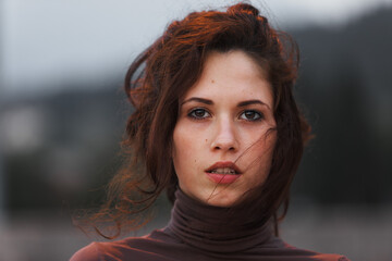 Wind-swept hair frames young woman's calm expression