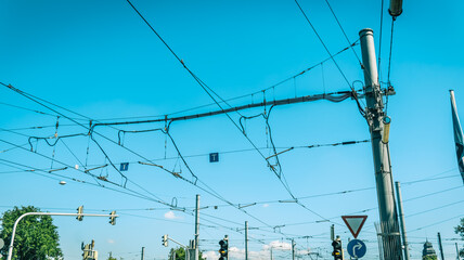 Electric wiring of city tram and bus traffic against blue sky