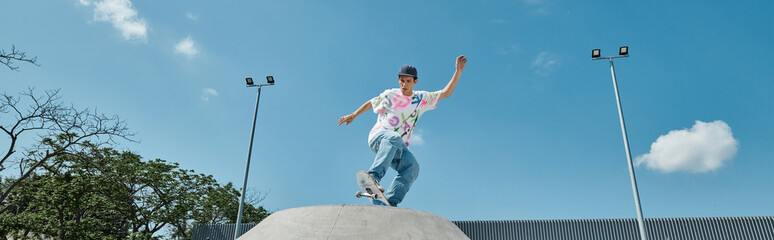 A young skater boy daringly rides his skateboard on top of a cement ramp at a skate park outdoors on a summer day. © LIGHTFIELD STUDIOS