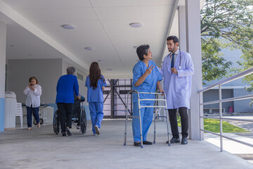 doctor or nurse helping Senior Woman to walk at nursing home with walker. Doctor or nurse helping...