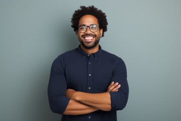 Portrait of a joyful afro-american man in his 30s with arms crossed in light wood minimalistic setup