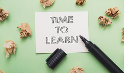 A marker is on a piece of paper that says Time to learn.
