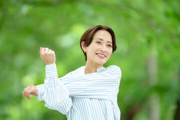 新緑の中でストレッチする女性